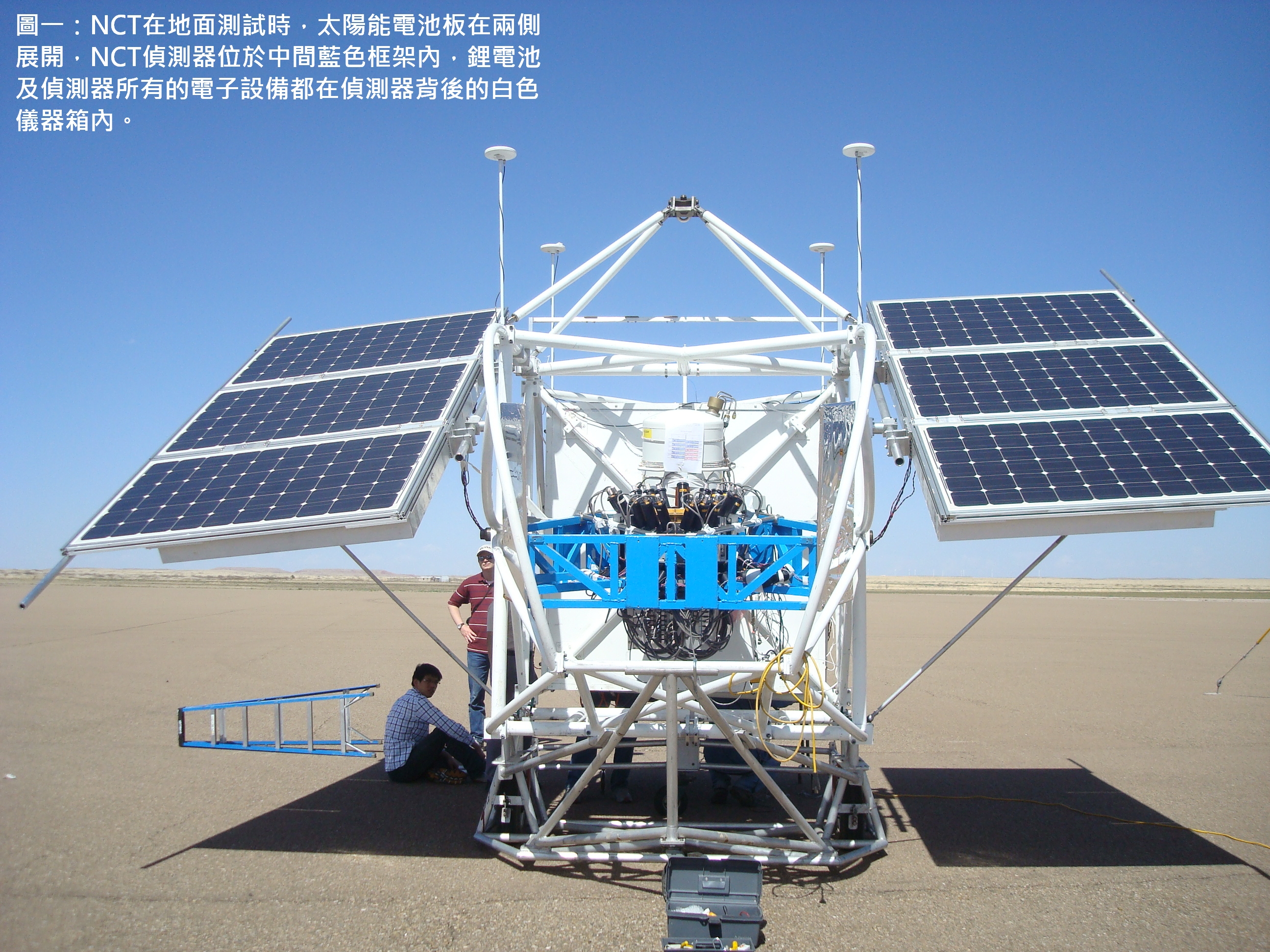 圖一：NCT在地面測試時，太陽能電池板在兩側展開，NCT偵測器位於中間藍色框架內，鋰電池及偵測器所有的電子設備都在偵測器背後的白色儀器箱內。