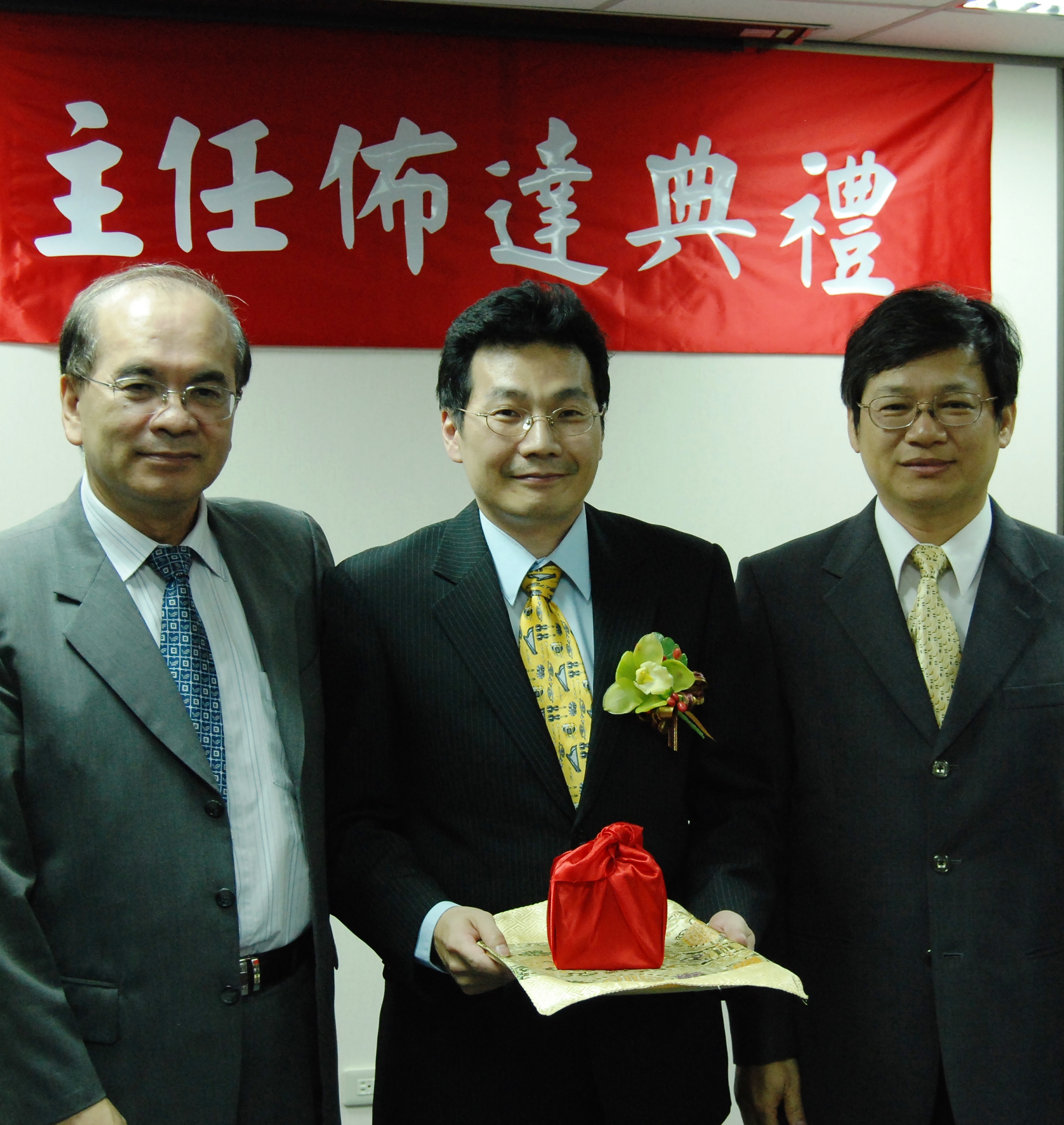 Overseen by President Wen-Hwa Chen (left), Acting Director General Yeong-Her Wang (right), gives the official seal to the new director general Bou-Wen Lin at the inauguration ceremony. 
