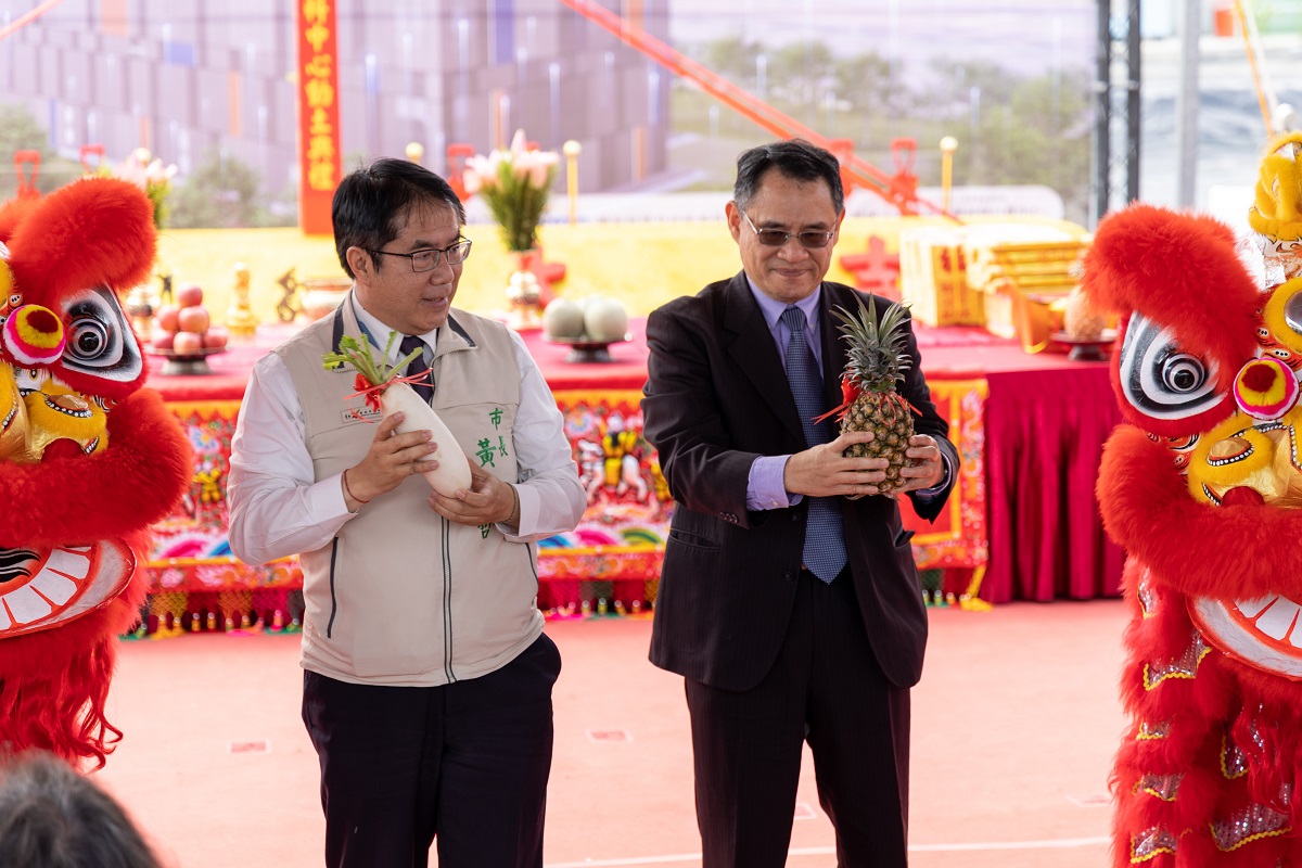 國研院林法正院長(右)和臺南市黃偉哲市長舉起鳳梨和菜頭象徵動土大吉